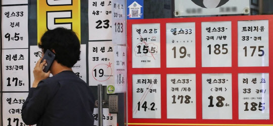 한 시민이 서울의 한 부동산공인중개업소 매물 게시판 앞에서 통화하고 있다.<연합뉴스>